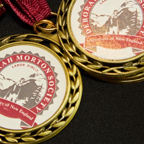 Several medals bearing the Deborah Morton Society seal are splayed out on a table