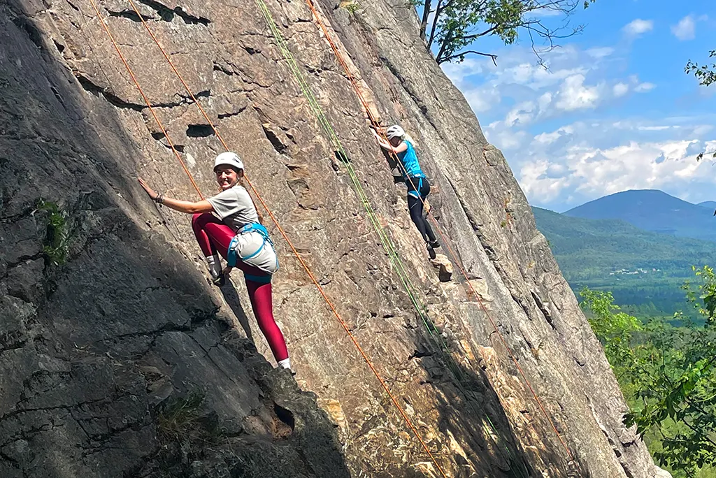 Two U N E students pose while rock climbing during a trailblazer pre-orientation trip