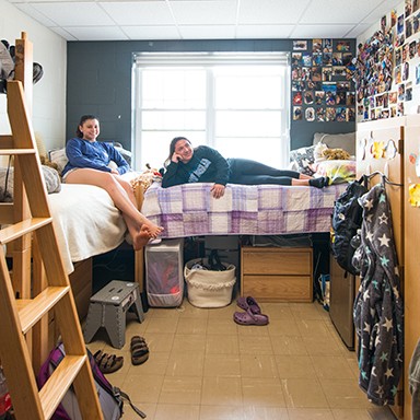 Two UNE Students watching television in their dorm room