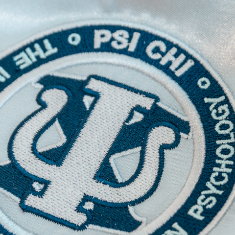 A photo of a stole bearing the PSI CHI logo