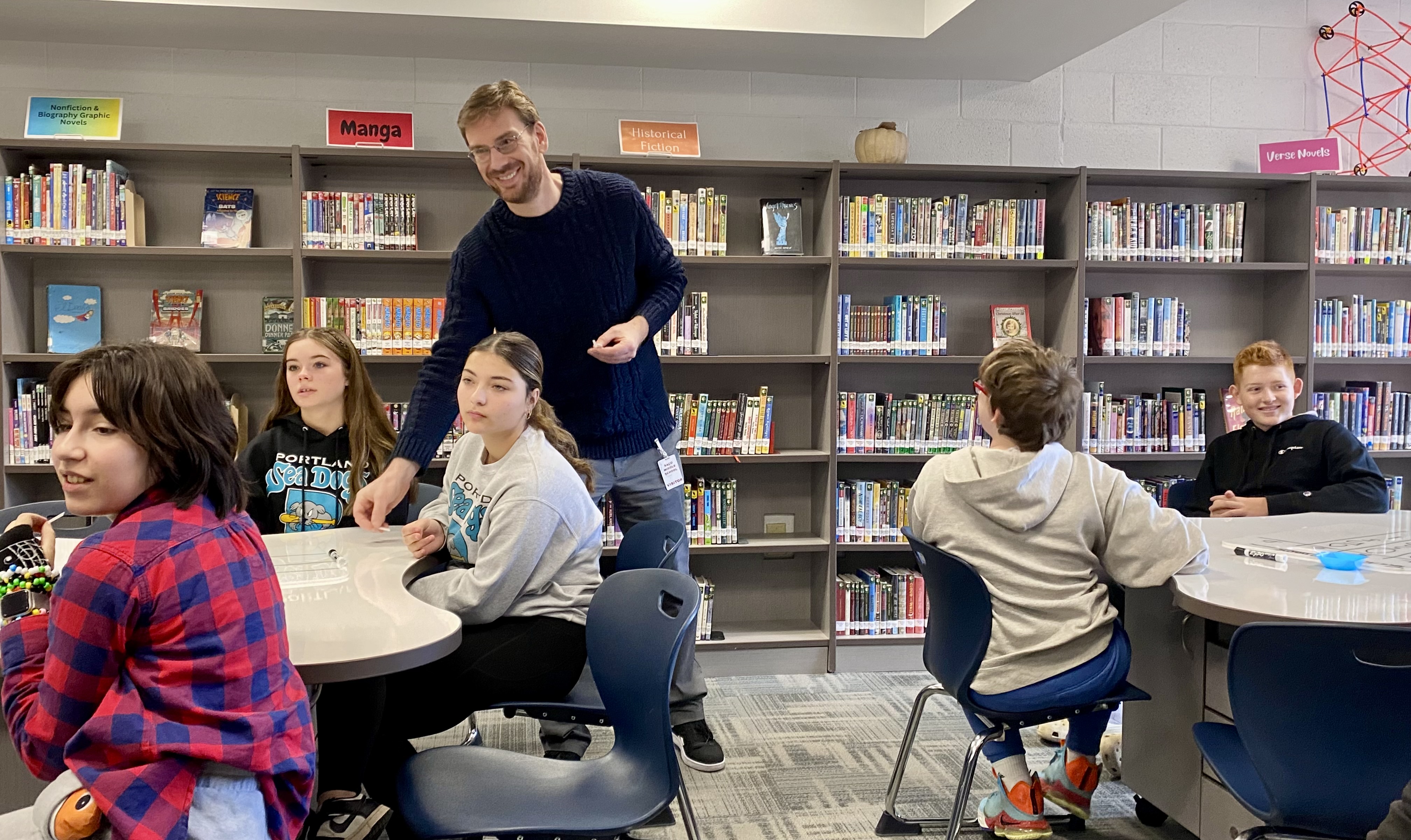 A UNE professor interacts with middle schoolers from Saco at Maine Bioscience Day