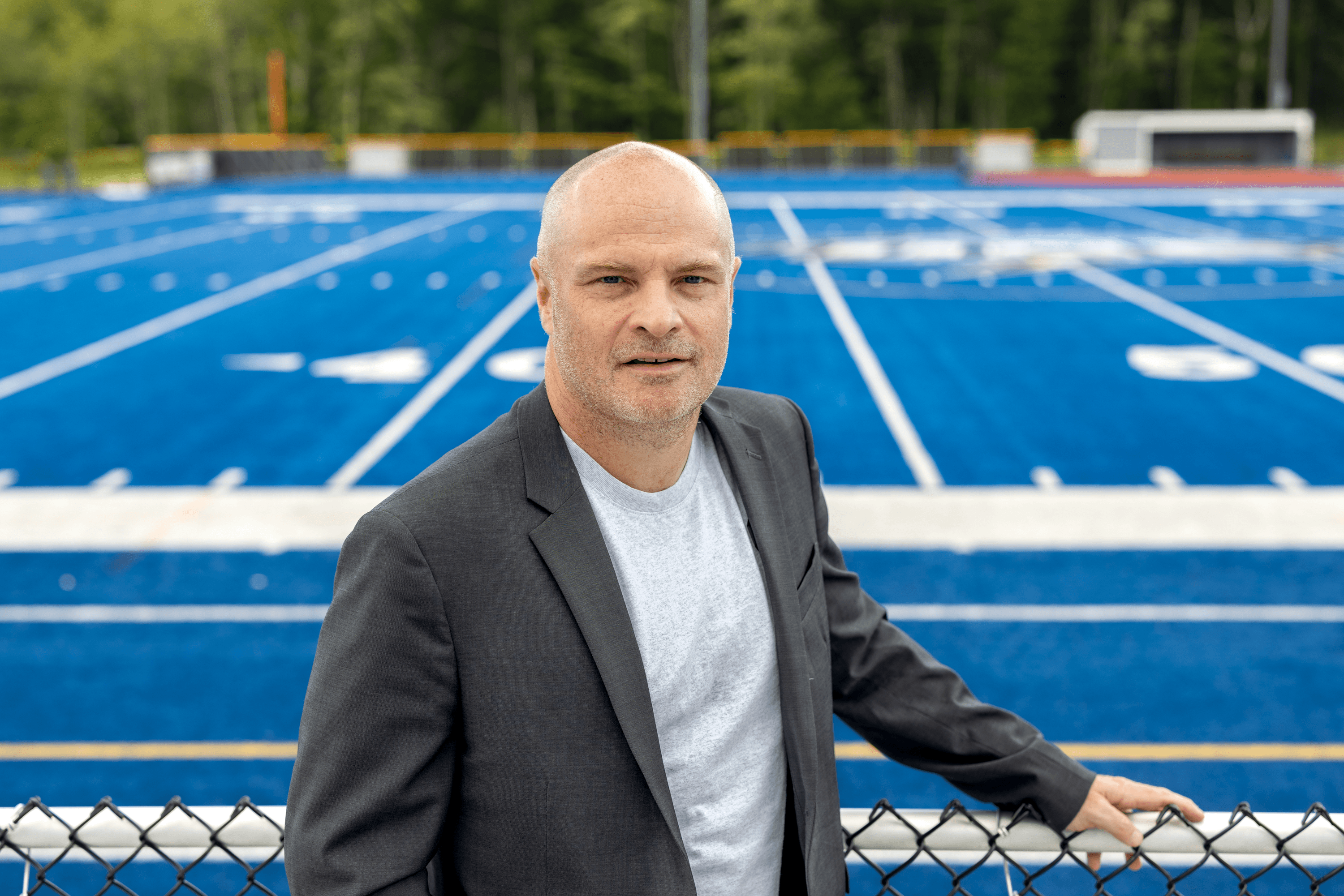 Portrait of Norm O'Reilly with the UNE football field in the background