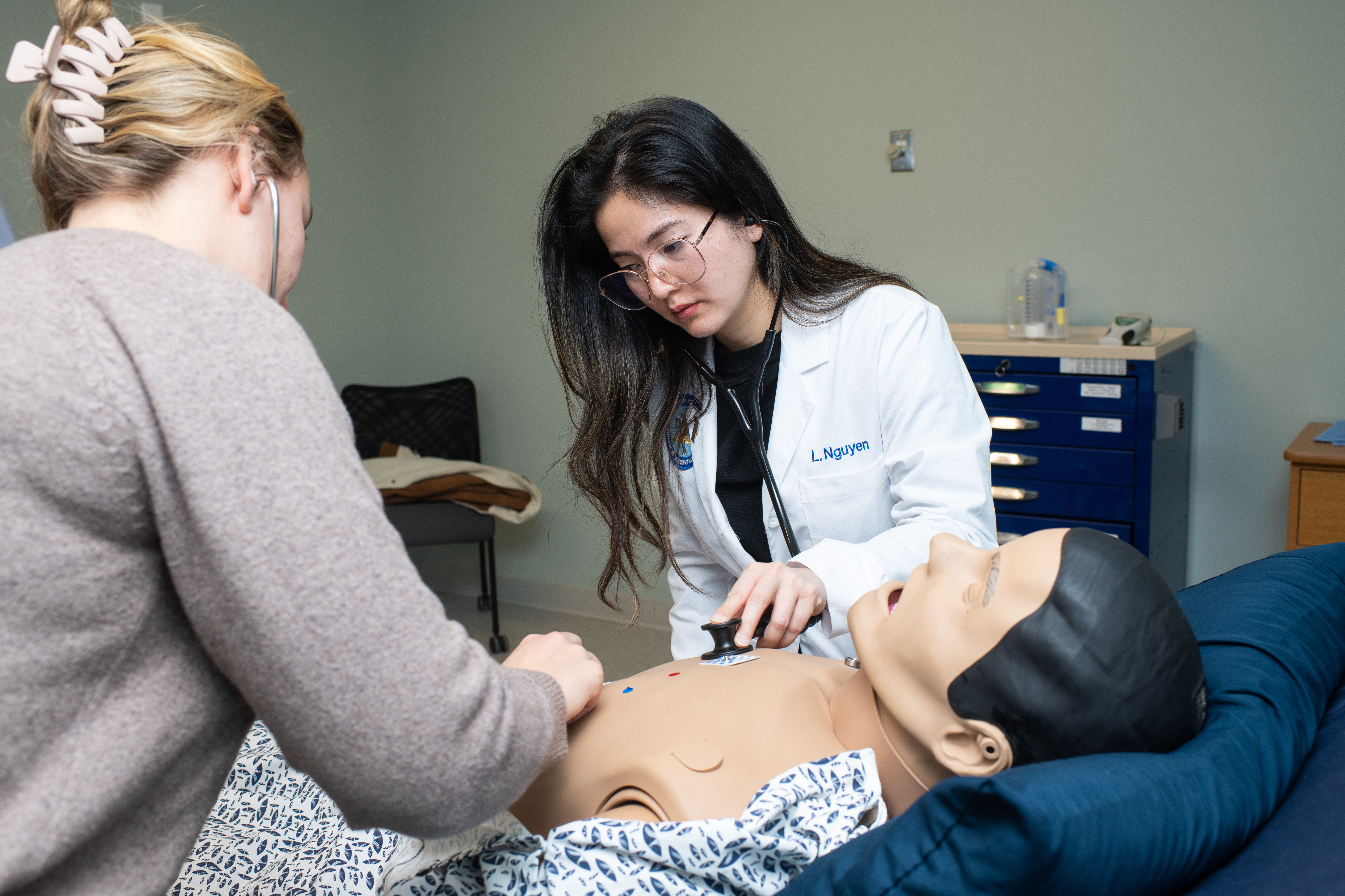 A medical student and PA student listen to the heartbeat of a high-fidelity patient simulation mannequin