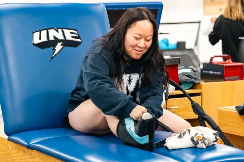 A student practices ice wrapping their leg in an athletic training lab