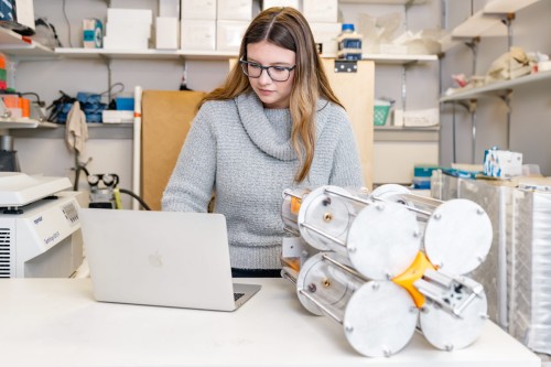 A marine science student works on their laptop in a lab