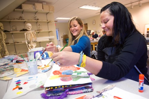 Two art students painting in class