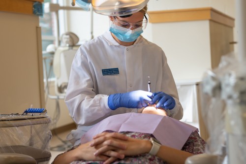 A dental hygiene student cleaning a patients teeth