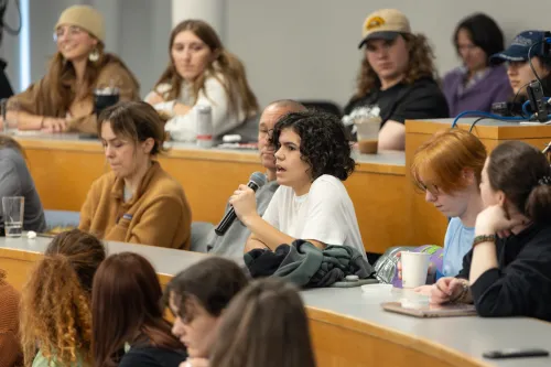 One student uses a microphone to speak during a lecture on climate change