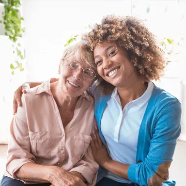 A young woman hugs an elderly woman