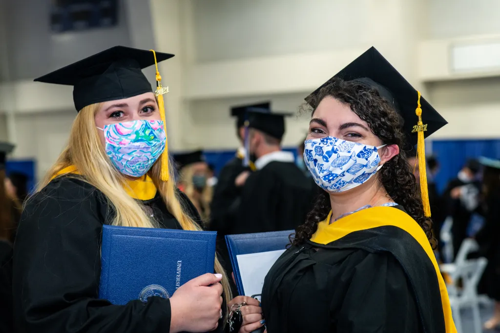 Students post for a photo at Commencement