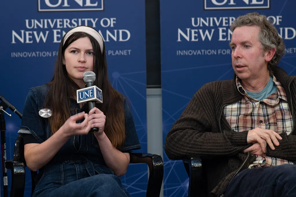 A U N E student asking a question on mic at an Environmental Council meeting