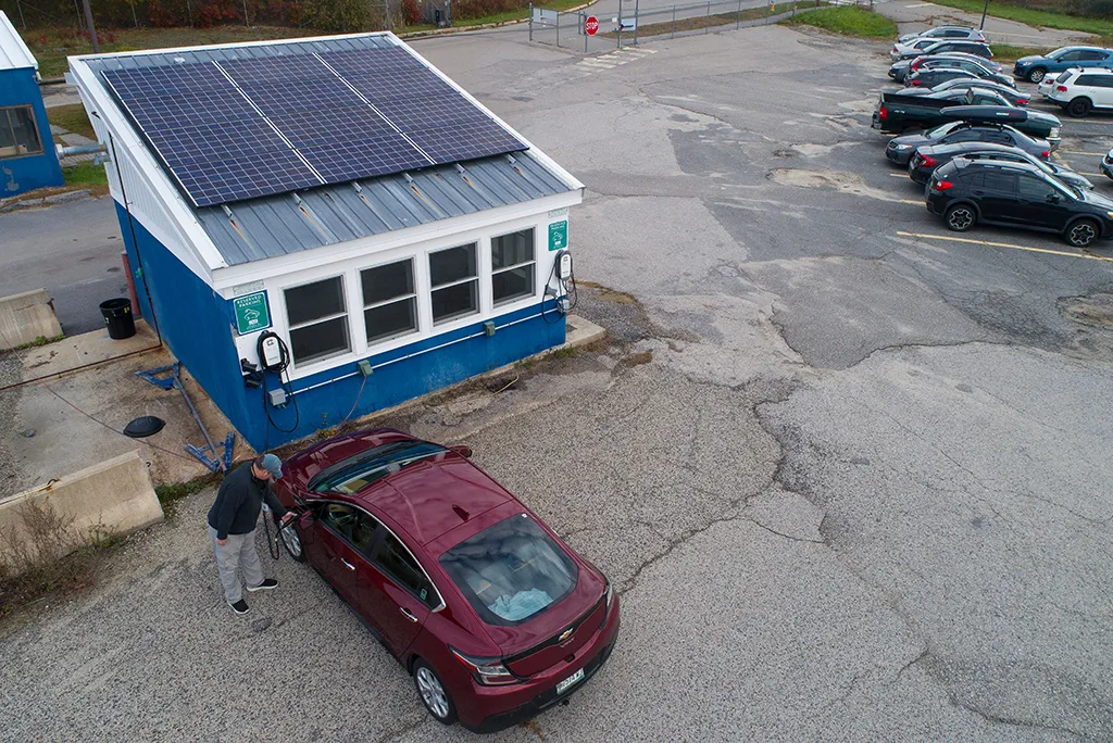 A man charges his electric car at a Portland Campus charging station