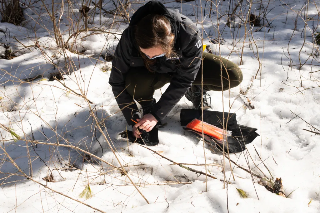 A student taking samples from snow for testing 