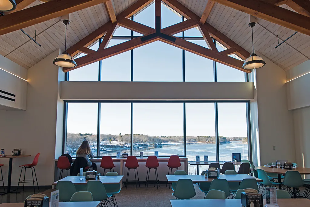 The inside of the dining hall in the Commons overlooking the Saco River