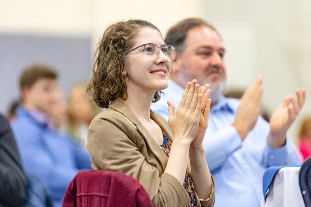 woman clapping facing the stage