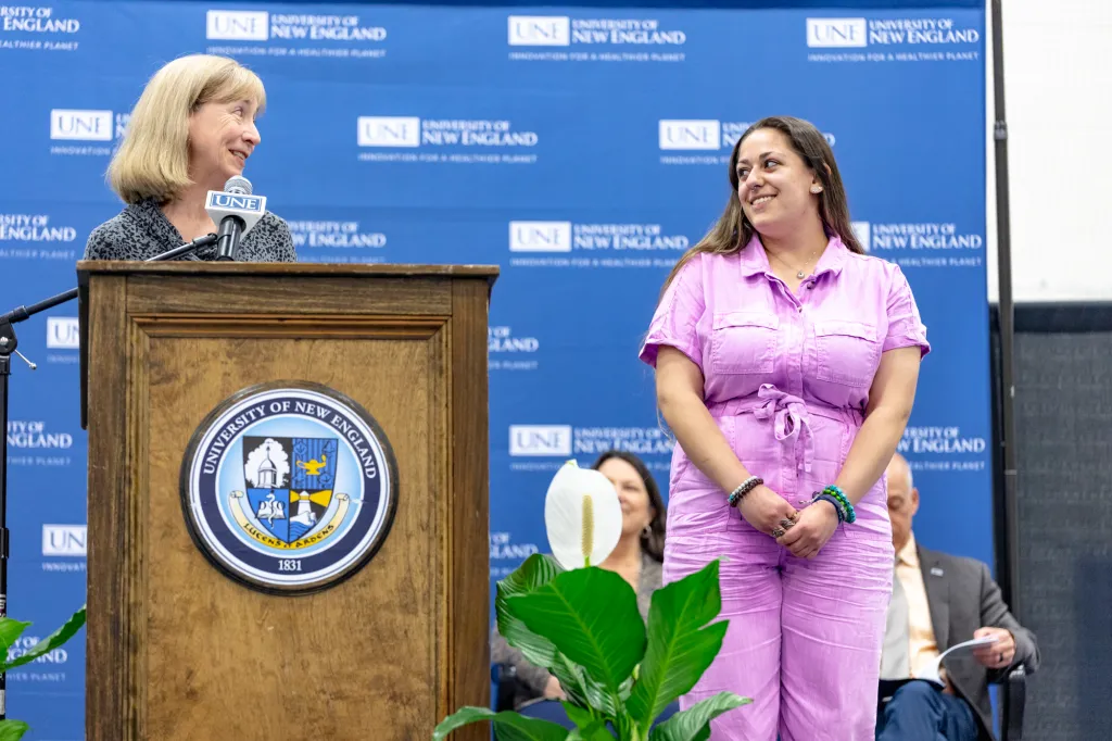 woman in purple accepting award on stafe