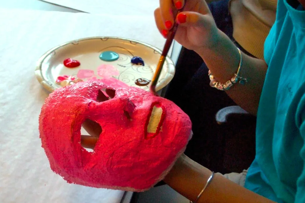 A student painting a mask