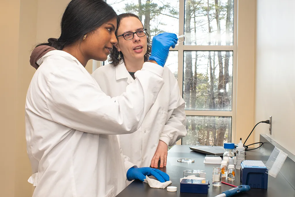 Two students looking at a microscope slide