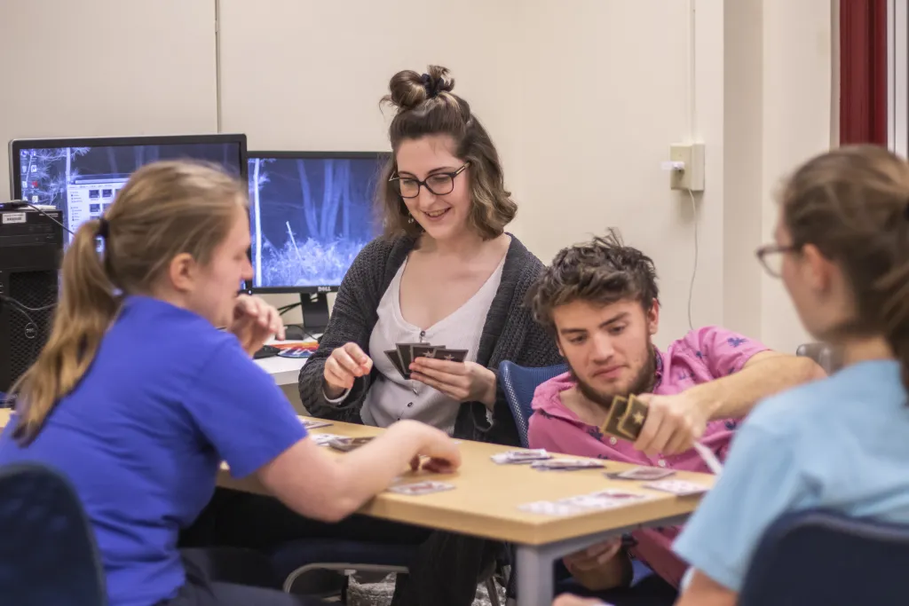 Four students playing a card game