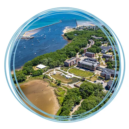 An aerial view of the Biddeford Campus featuring brick buildings, the Saco River, and Atlantic Ocean