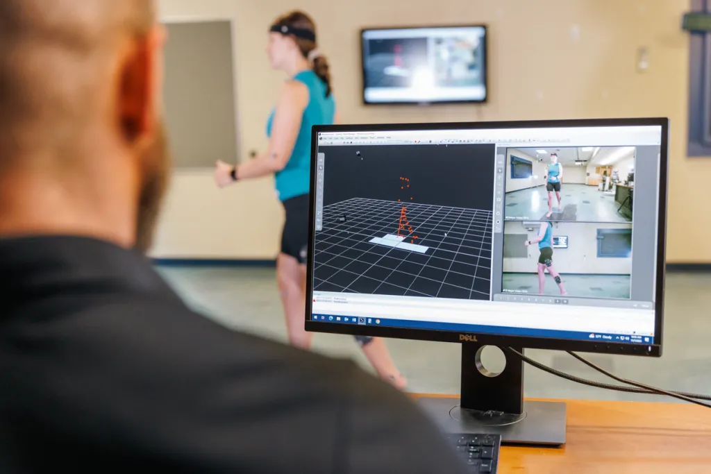 A professor looks at a monitor that displays motion information based on a student's movements