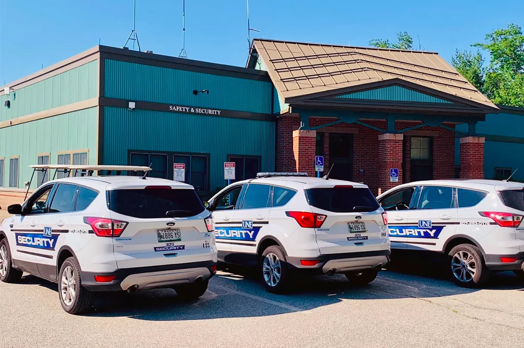 Three U N E security vehicles lined up outside the Safety and Security building