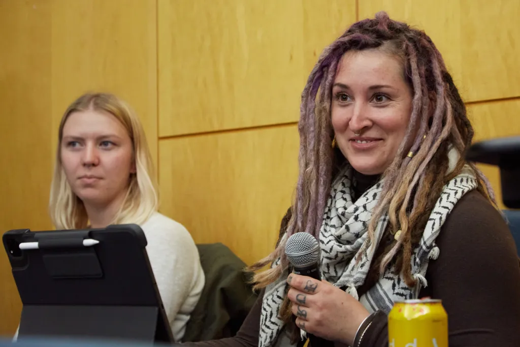 A U N E graduate student uses a microphone to ask a C G H speaker a question