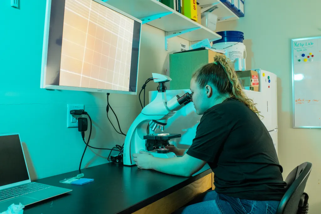 student looking into microscrope