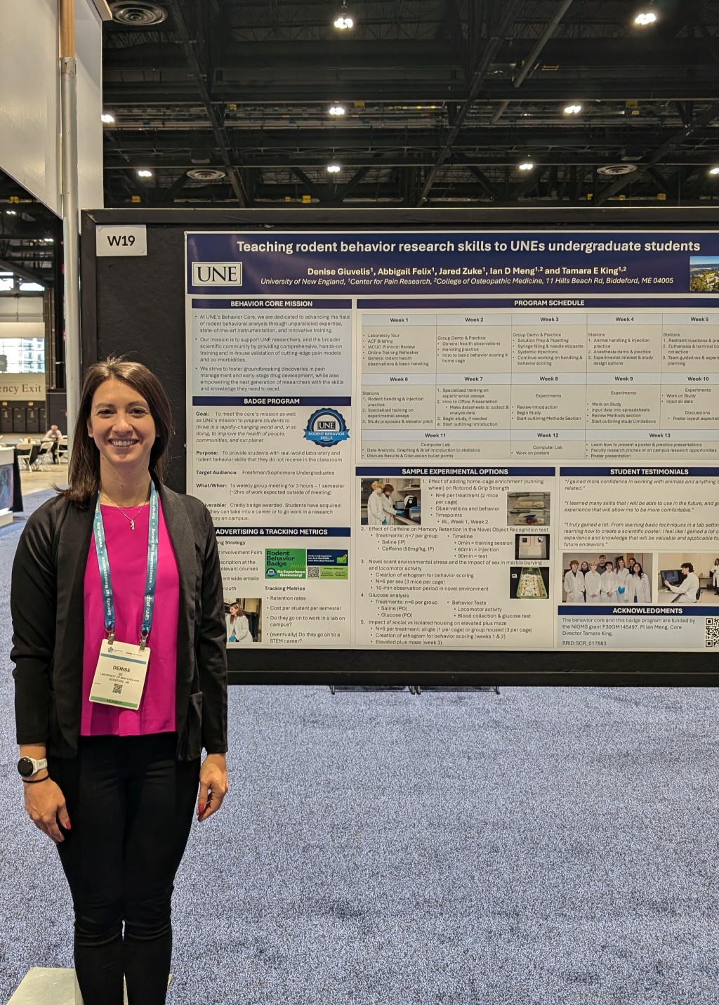 Denise Giuvelis, B.S., stands in front of her poster