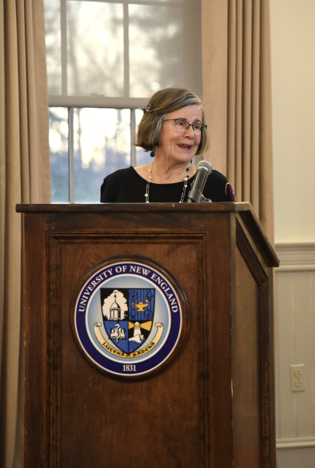 Nancy MacRae speaks at the podium