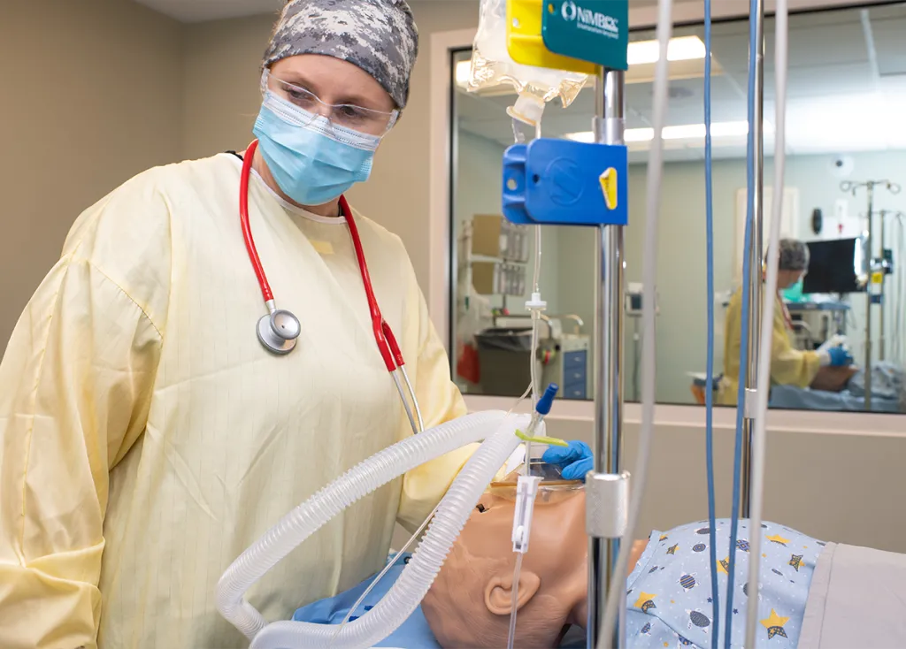 A nursing anesthesia student works on a patient simulator in the Sim Lab