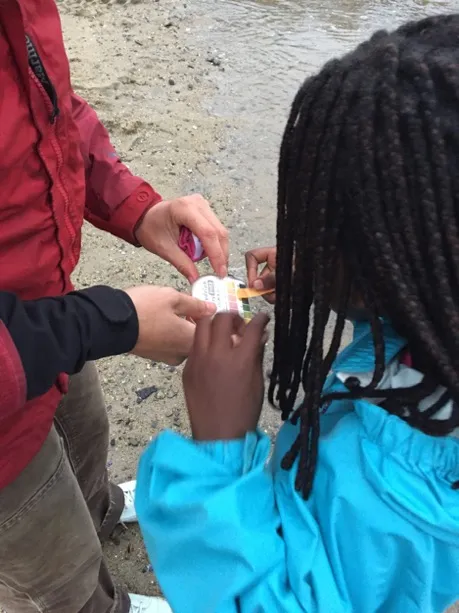 Gretchen Grebe, Ph.D. candidate based at UNE, helps students test water pH values