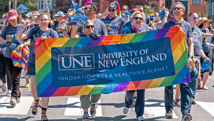 A group of U N E employees and students walk in a Portland, Maine Pride Parade