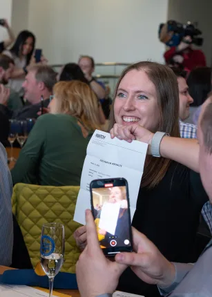 A student celebrates her match as a friend films her reaction