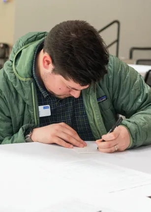 A student writes a postcard