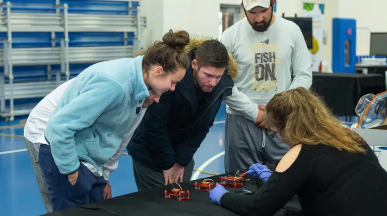 Three students learning about circuitry at a U N E Brain Fair