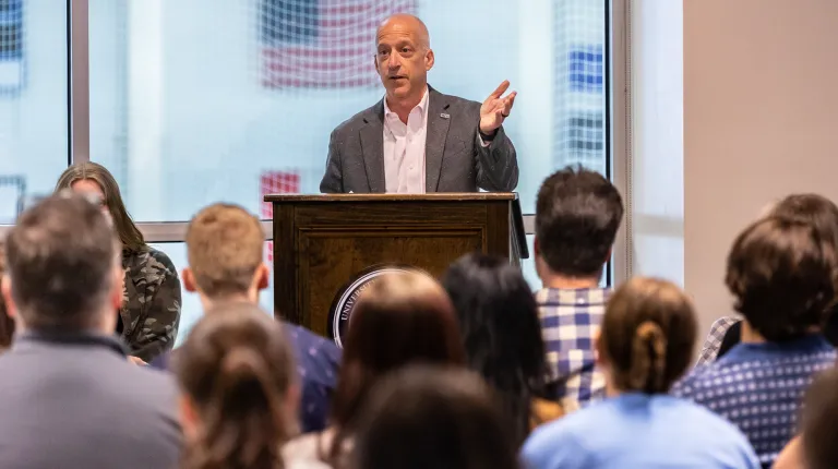 Dean Jonathan Millen speaks at a podium