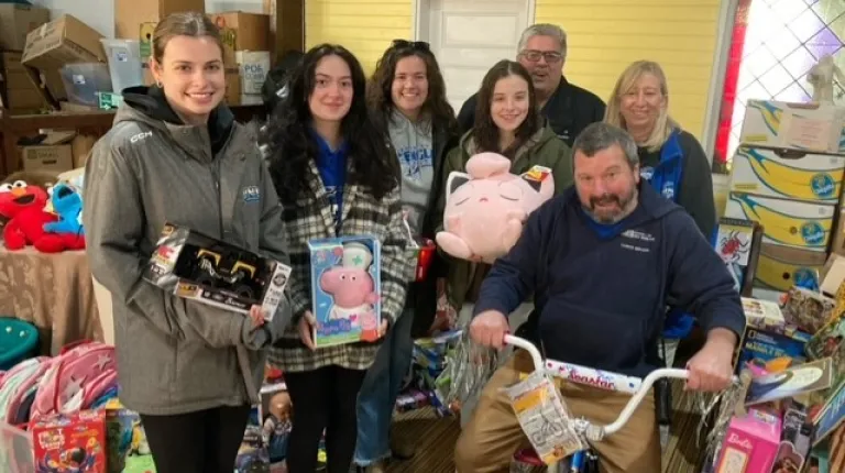 Students and volunteers pose in the Gift Room at Seeds of Hope