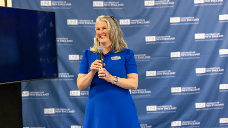 UNE's Alethea Cariddi speaks into a microphone