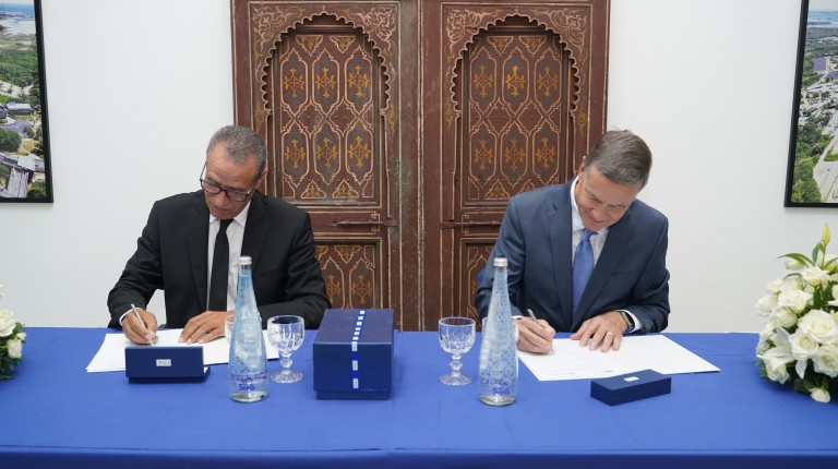 UNE President James Herbert and President Bouchta El Moumni of Abdelmalek Essaadi University sign an agreement at a formal table