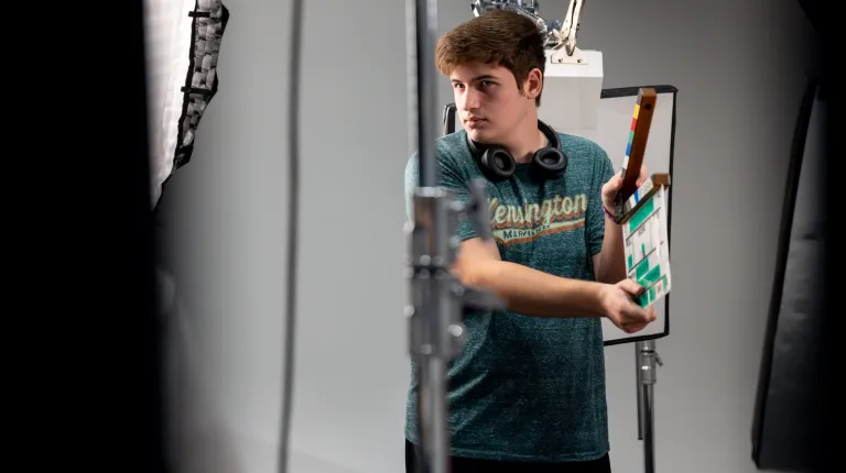 A UNE student claps a production slate