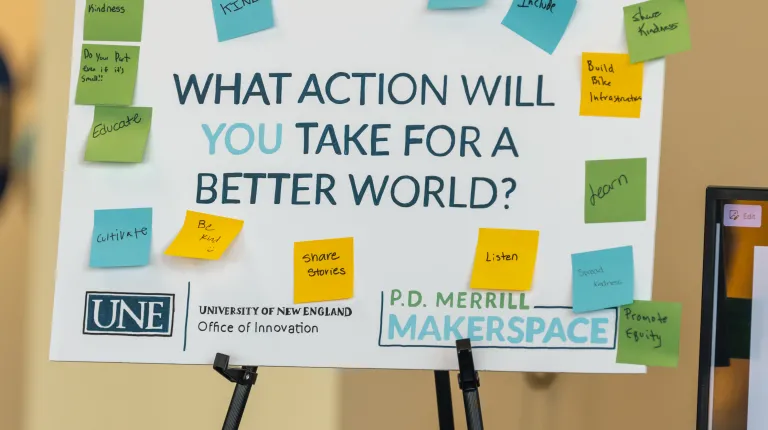 A sign with sticky notes on it reads “What action will you take for a better world?”