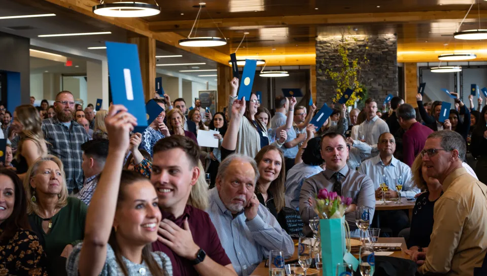 UNE COM students hold up their residency match envelopes