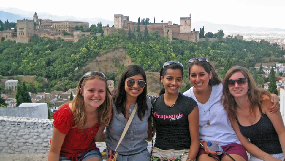 Five U N E students take a photo in front of an old Spanish fortress and palace