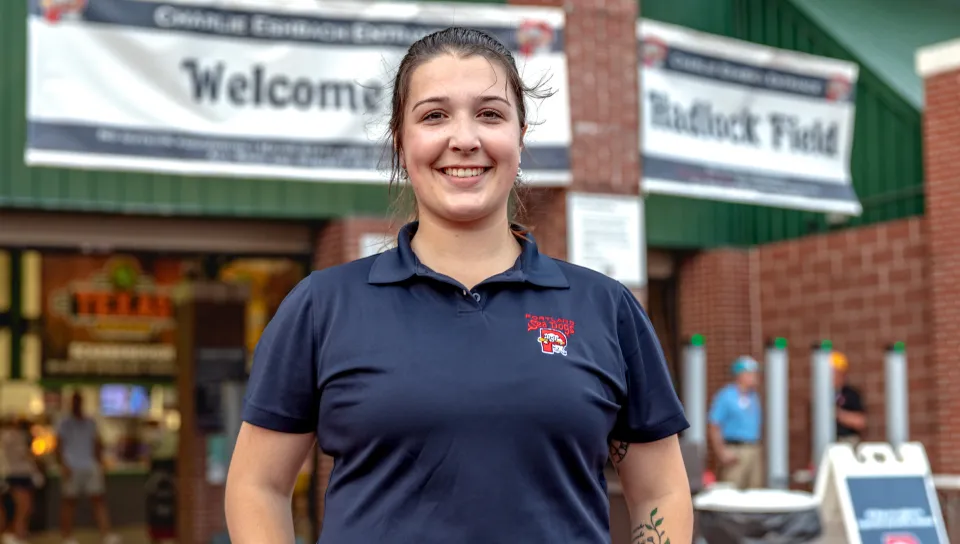 A UNE student poses in front of the Hadlock Field entrance