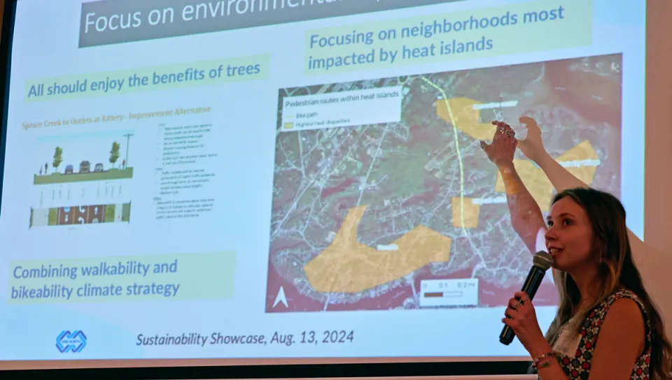 A student gives a presentation about environmental equity on a projection screen