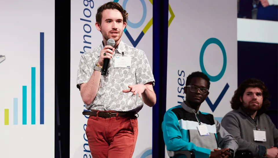 A student speaks on stage at an Innovation Challenge event