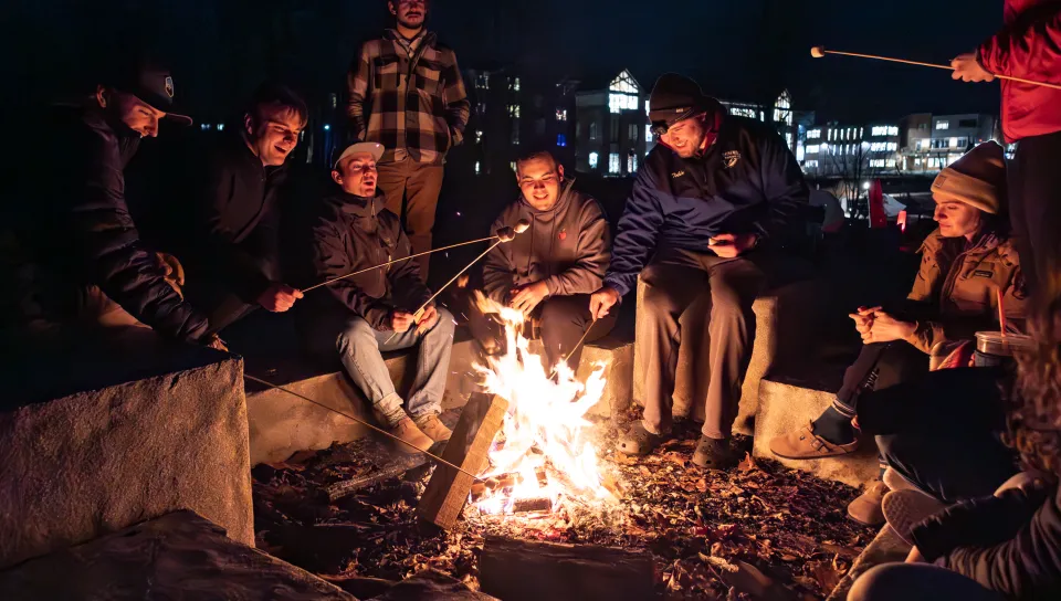 Students roast marshmallows over a bonfire at Jordan Point