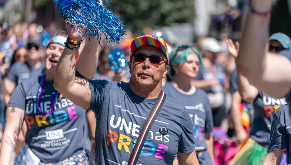 A UNE employee marches in the Pride parade in downtown Portland in June 2024