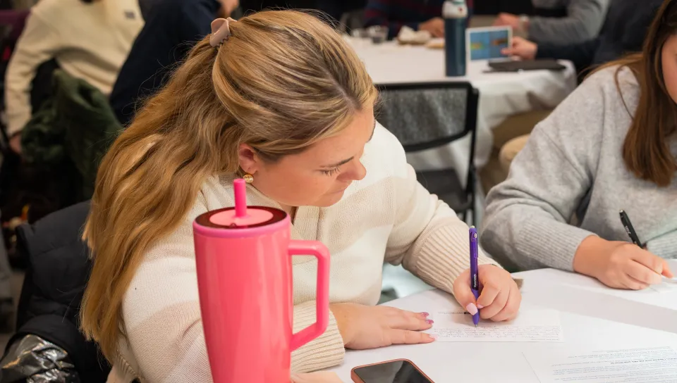 A student writes a postcard